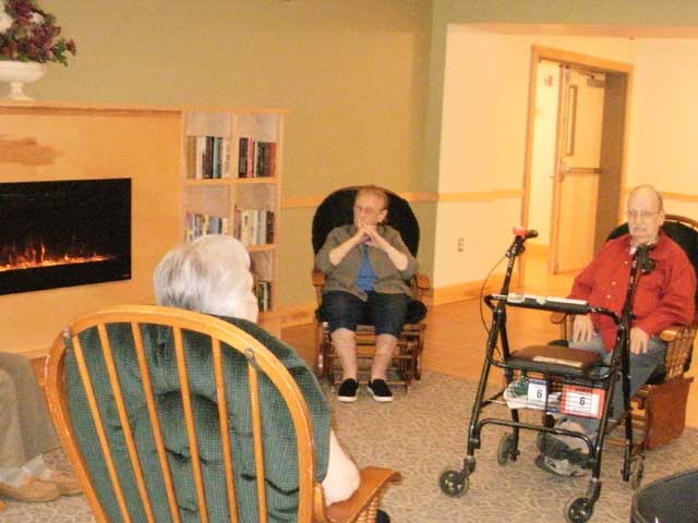 Residents relax around the fireplace after a potluck meal.